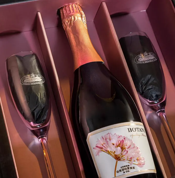 Estuche corporativo con botella de cava y dos copas grabadas con el logotipo de la bodega